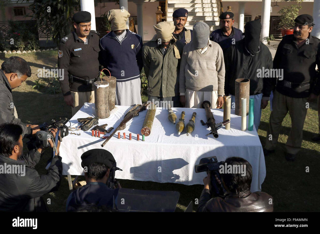 La policía exponer a los terroristas asociados con la extinta Lashkar-e-Jhangvi Mathra arrestados durante la redada en el área de Peshawar, en el CPO de Peshawar, el martes, 15 de diciembre de 2015. La policía detuvo a 02 cohetes, 02 lanzadores, 01 ametralladoras pesadas y contienen bombas explosivas de los delincuentes detenidos. Foto de stock