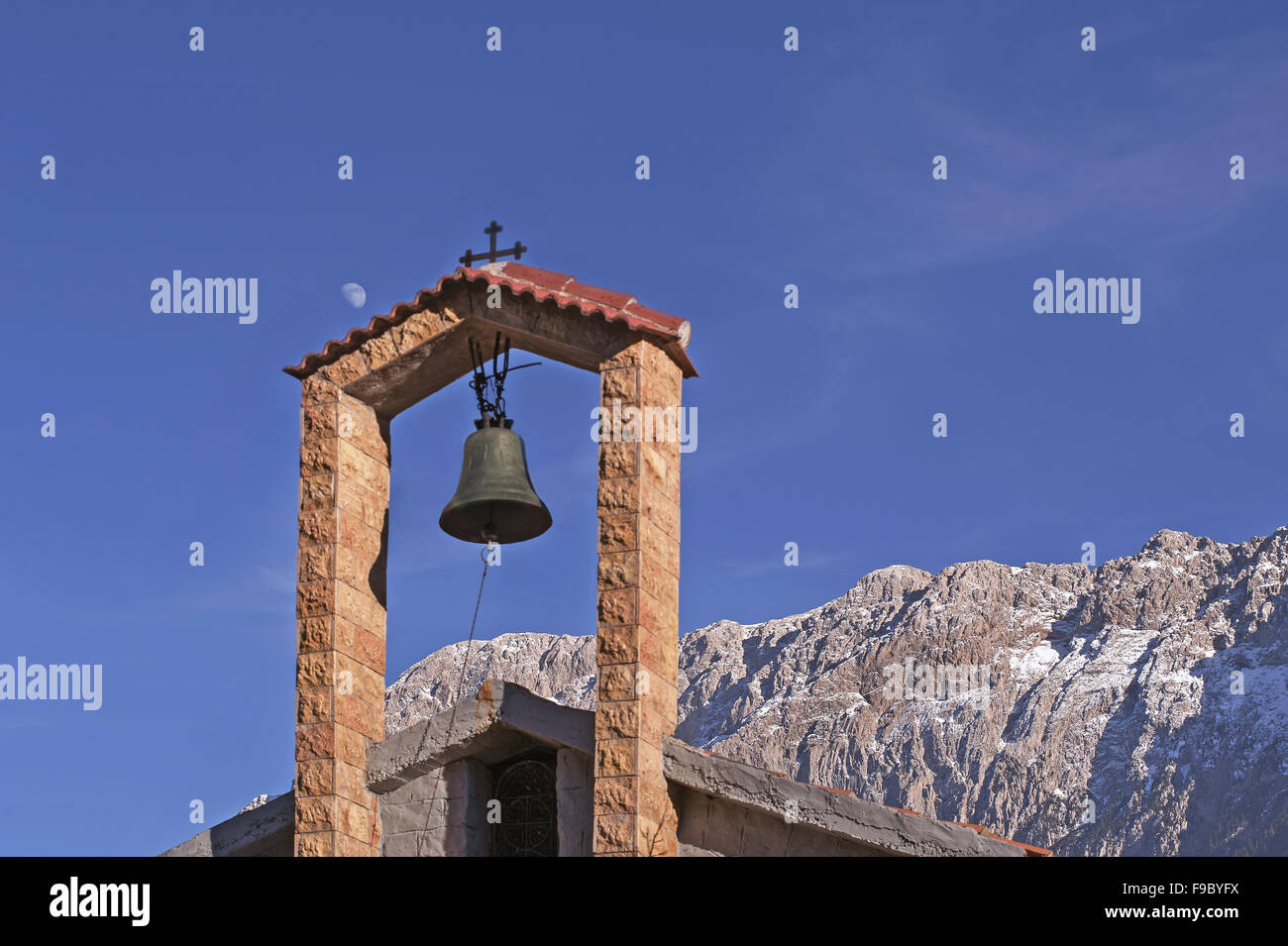 Vistas a la montaña nevada Giona posando en el fondo de una torre-campanario cerca de Galaxidi ciudad de Fokida región, Grecia Central Foto de stock