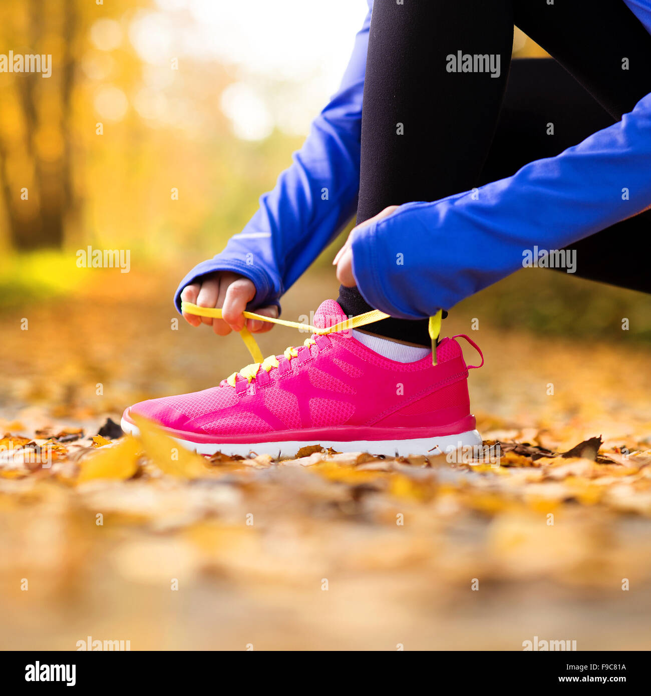 Cerca de los pies de un corredor corriendo en hojas de otoño ejercicio de entrenamiento Foto de stock