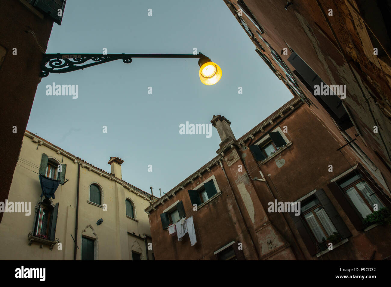 Ver hacia arriba entre las casas en Venecia al atardecer Foto de stock