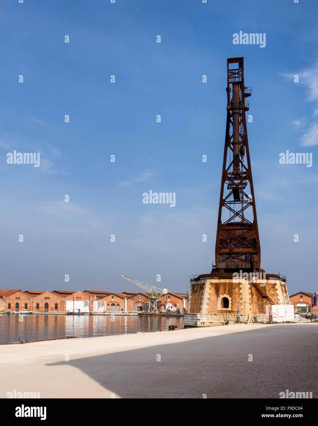 Grúa vieja y edificios históricos en el Arsenal veneciano, Puerto Venecia Italia Foto de stock