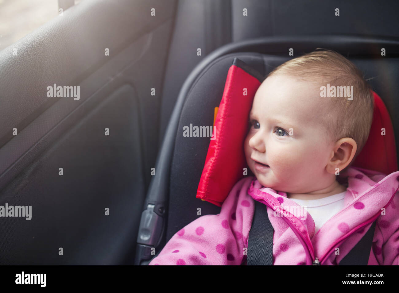 Hijita en un coche en un asiento para niños Foto de stock