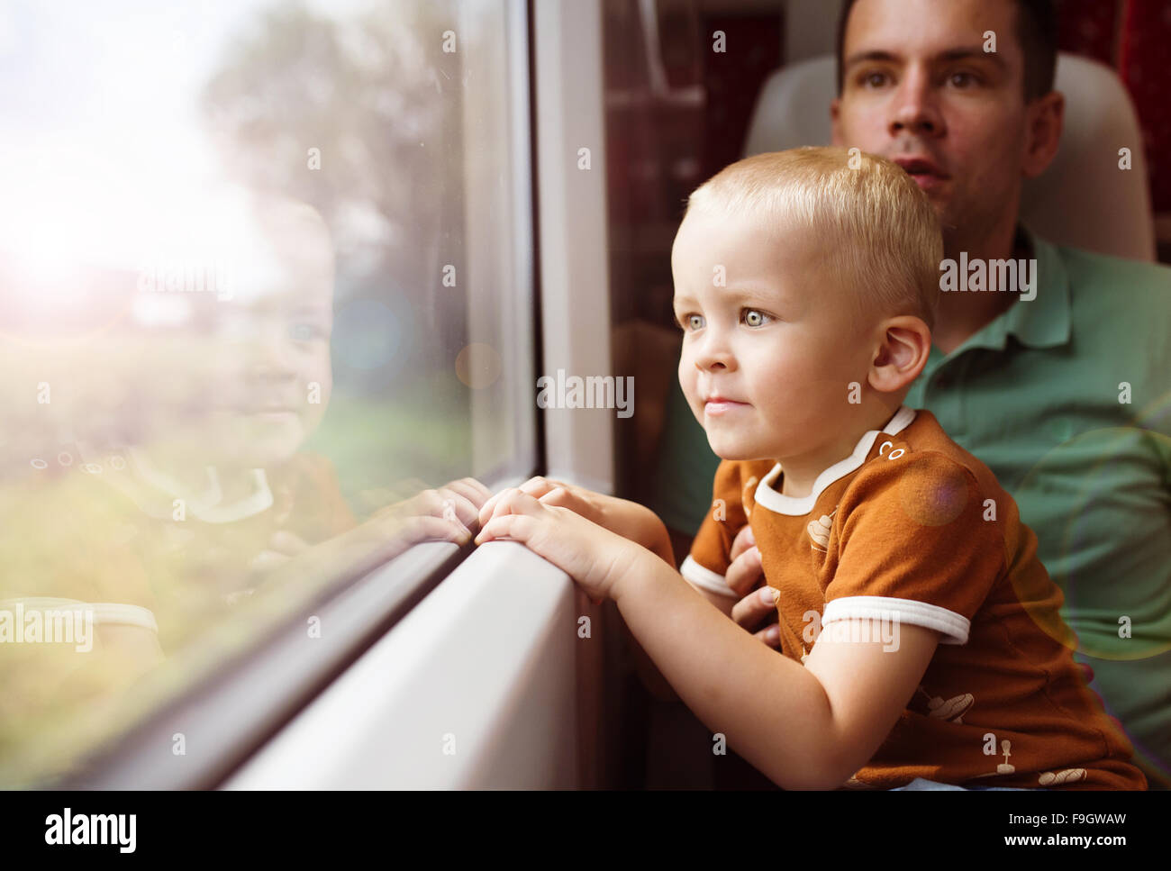 El padre con el hijo en su regazo viajando en tren. Foto de stock