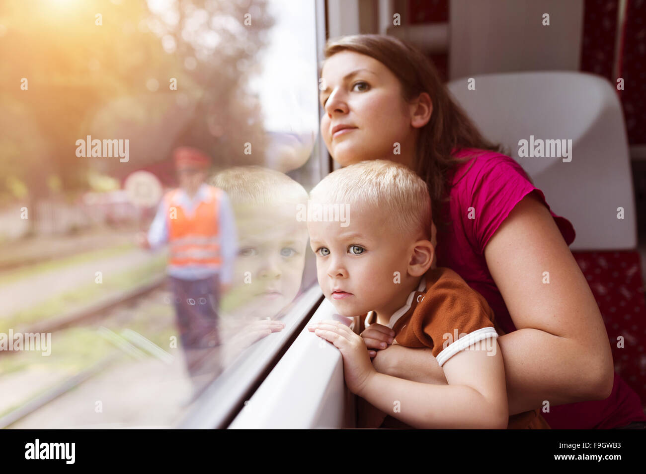 Madre con su hijo en su regazo, viajando en tren. Foto de stock
