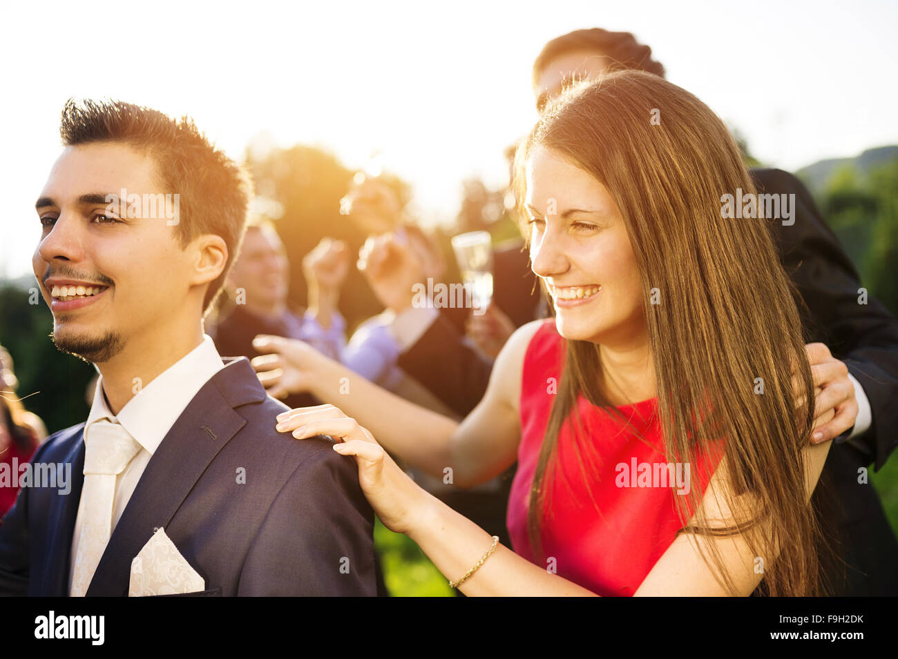 Retrato de longitud completa de los invitados a la boda bailando y divirtiéndose en la boda garden party en un verde parque soleado Foto de stock