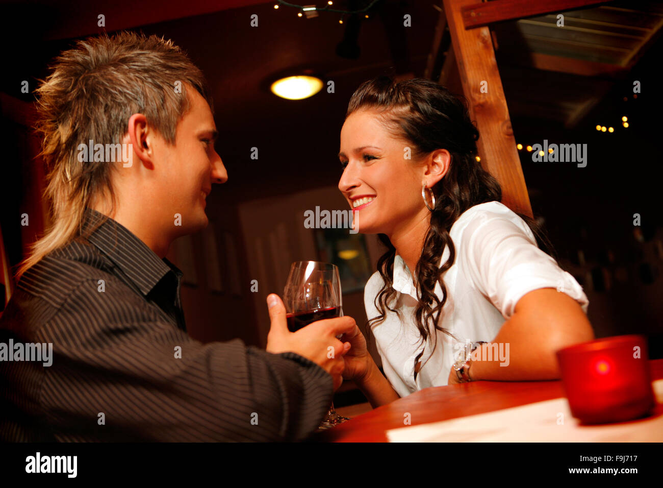 Joven pareja amada bebiendo vino en el bar. Foto de stock