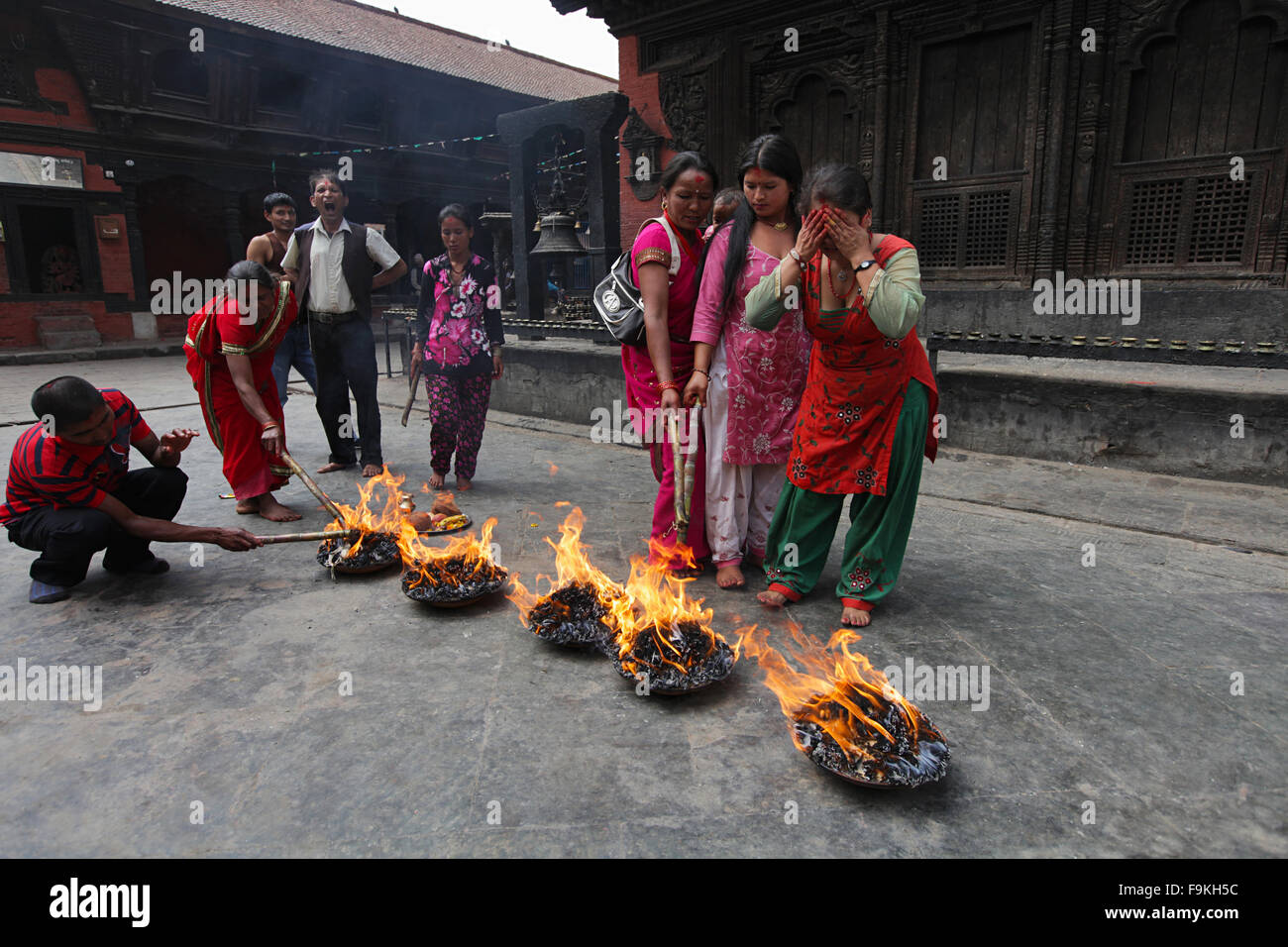 Los devotos iluminación mechas de aceite durante un ritual. Kahtmandu, Nepal. Foto de stock