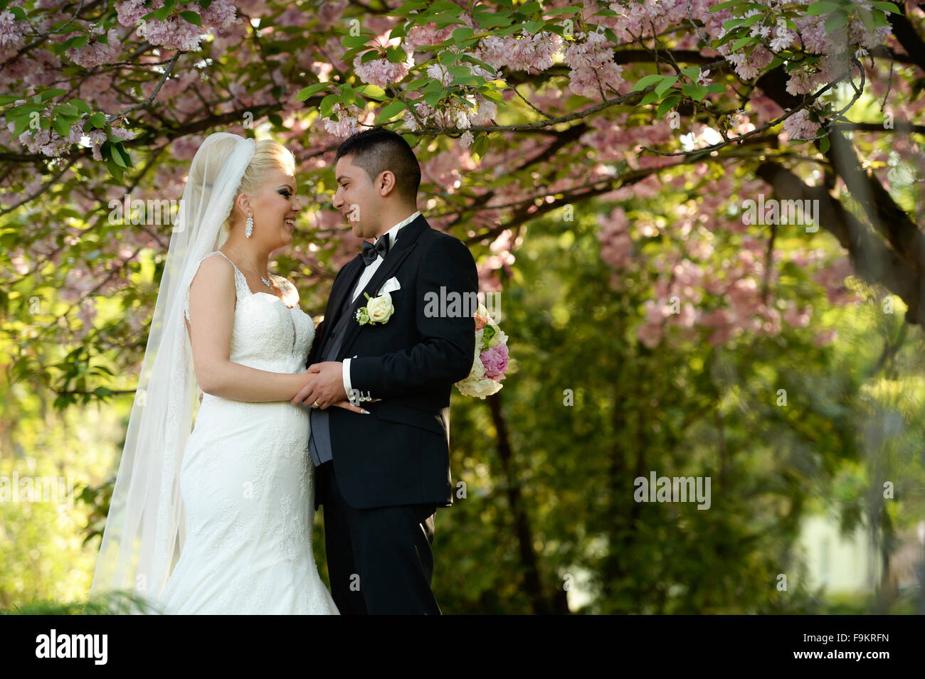 Feliz pareja nupcial en el día de la boda abrazar en la naturaleza Foto de stock