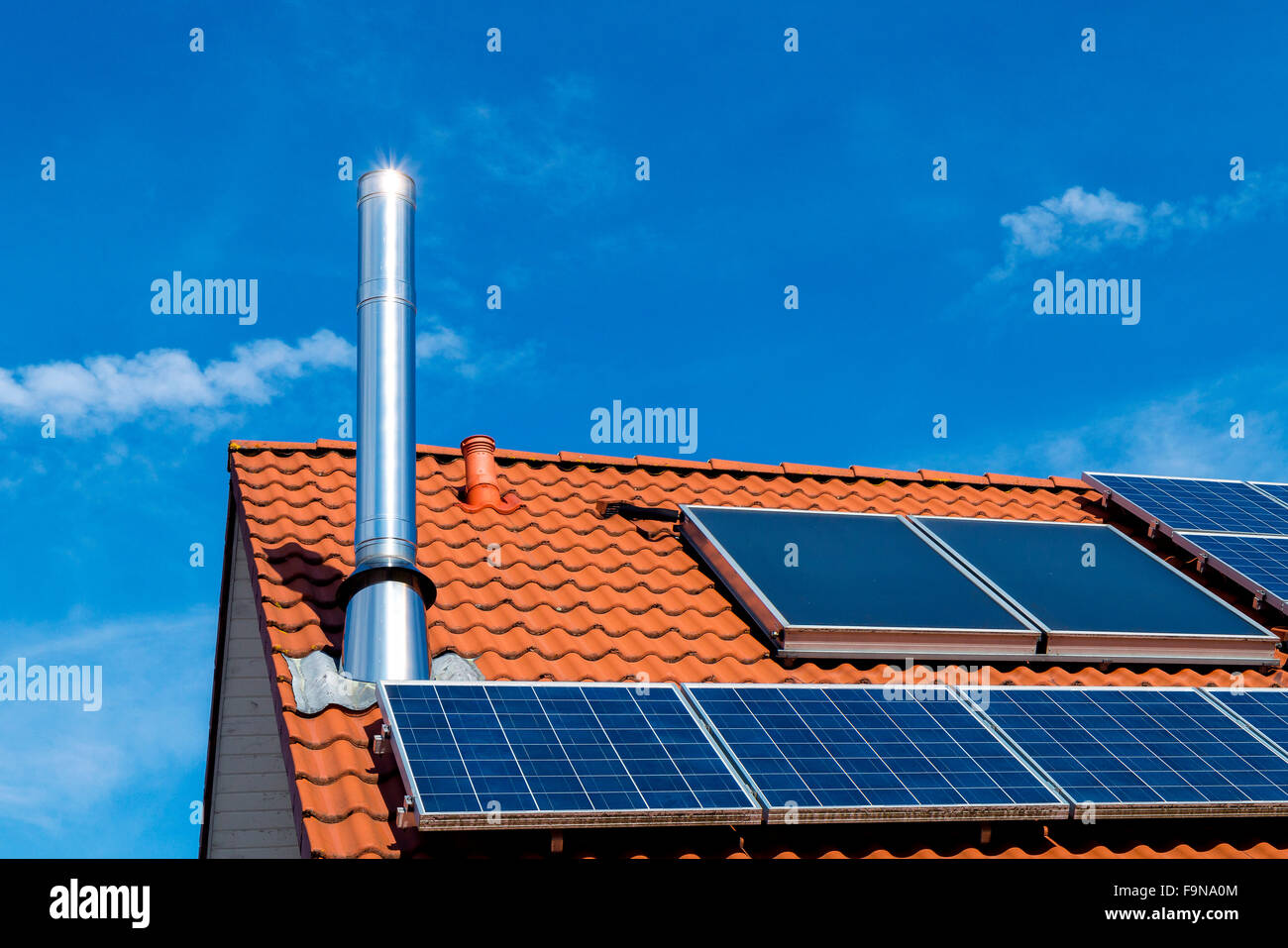 Casa con techo de paneles solares, acero inoxidable de chimenea, transición energética Foto de stock