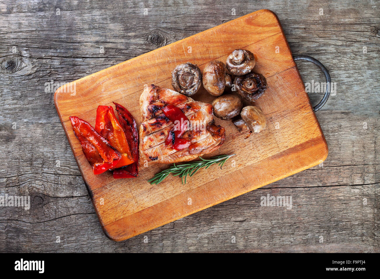 Deliciosas verduras y filete sobre una tabla de cortar de madera Foto de stock