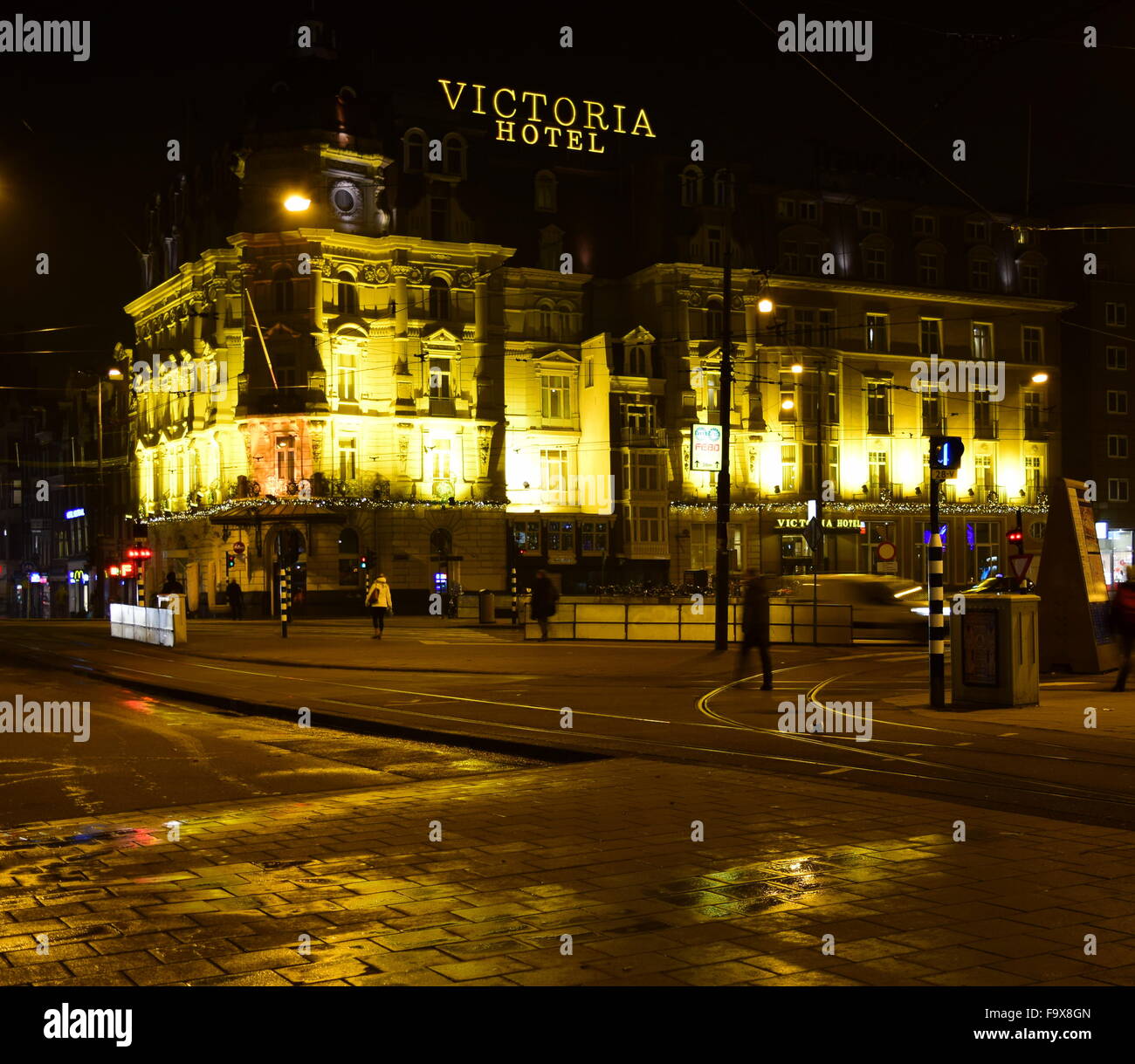 El encantador hotel Victoria en el centro de Amsterdam, como se ve en la oscuridad de una noche clara. Foto de stock
