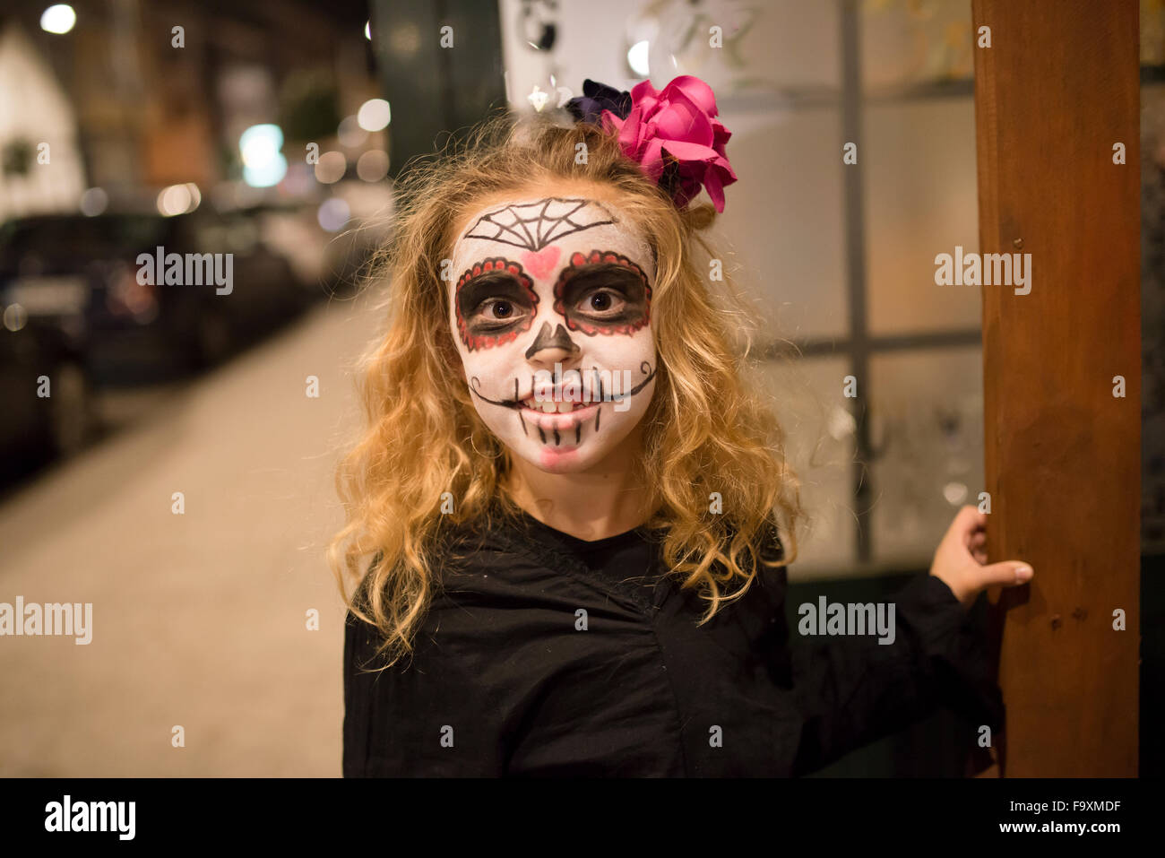 Niña rubia con calaveras de azúcar en Halloween maquillaje Foto de stock