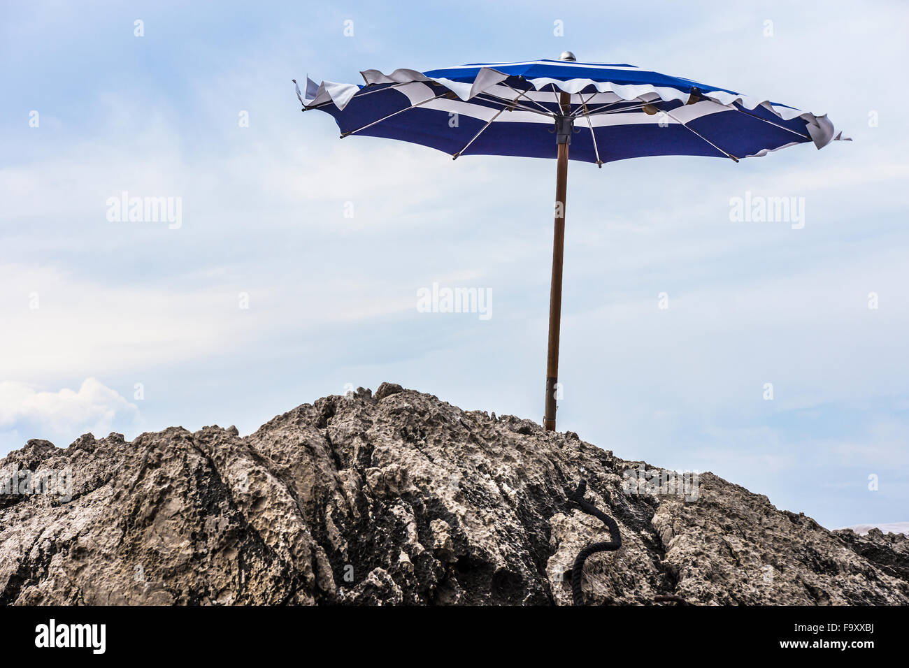 Italia, Capri, la sombrilla en costa rocosa Foto de stock