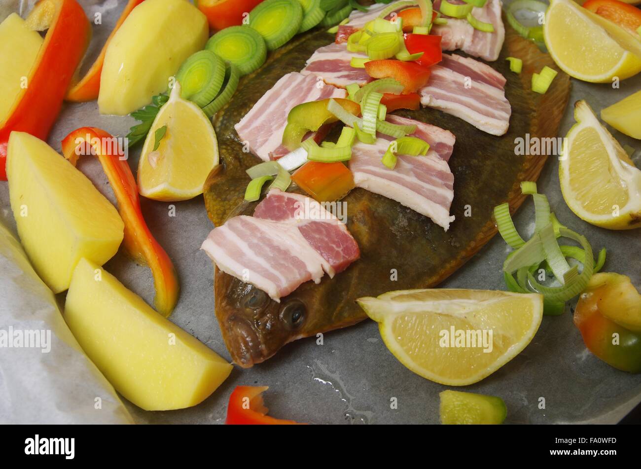 Pescado crudo platija con verdura y bacon. Foto de stock