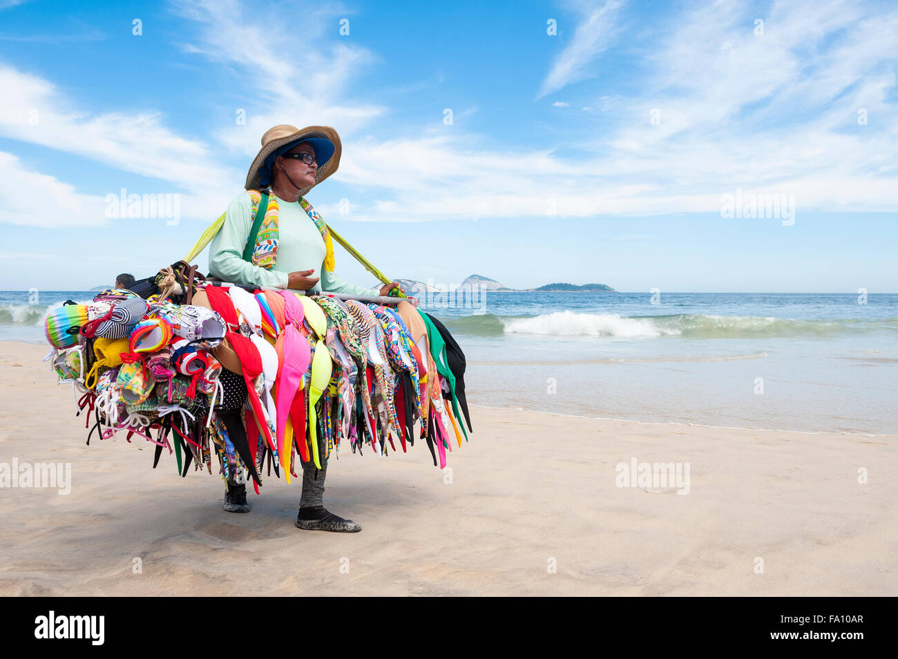 Río de Janeiro, Brasil - 15 de marzo de 2015: un proveedor de Playa Venta de bikinis lleva su mercancía a lo largo de la playa de Ipanema. Foto de stock