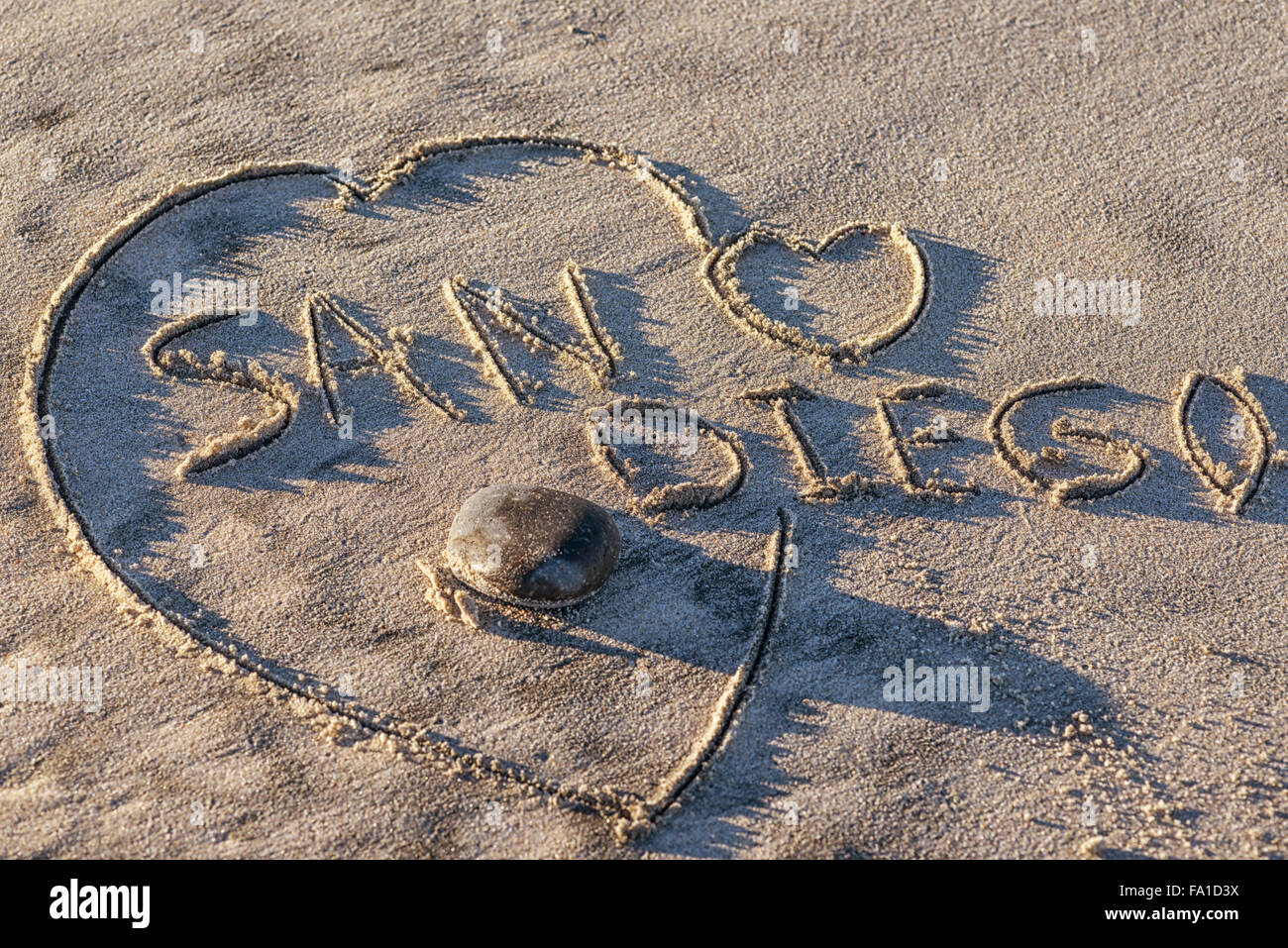 La palabra escrita de San Diego en la arena de la playa, con forma de corazón. Foto de stock