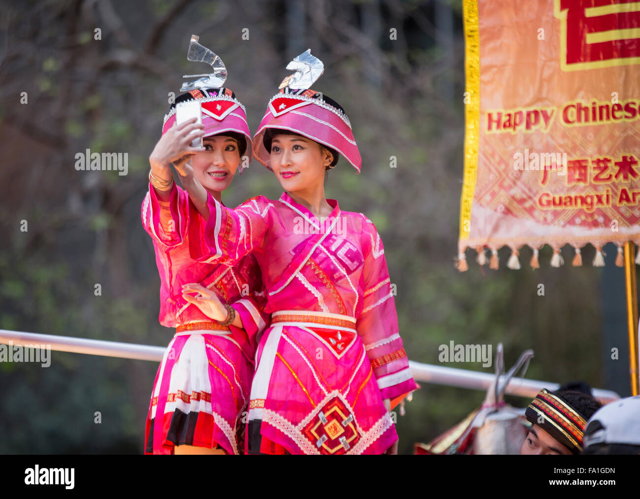 Las mujeres chinas vestidas en trajes coloridos teniendo un selfie encima de flotación en San Francisco el desfile del Año Nuevo Chino. Foto de stock