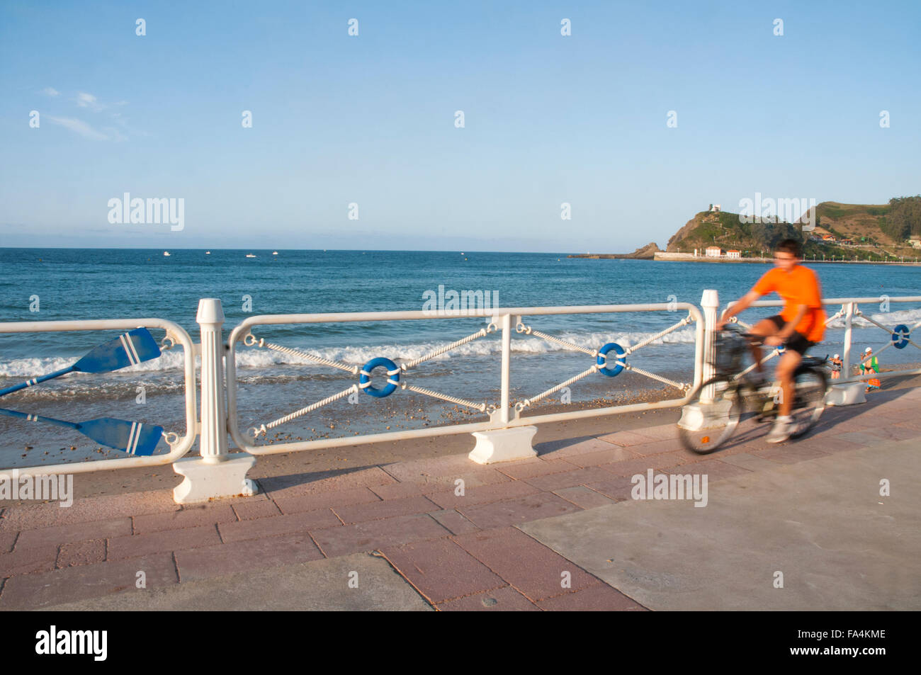 Ciclista en el paseo marítimo. Playa de Santa Marina, Ribadesella, Asturias, España. Foto de stock
