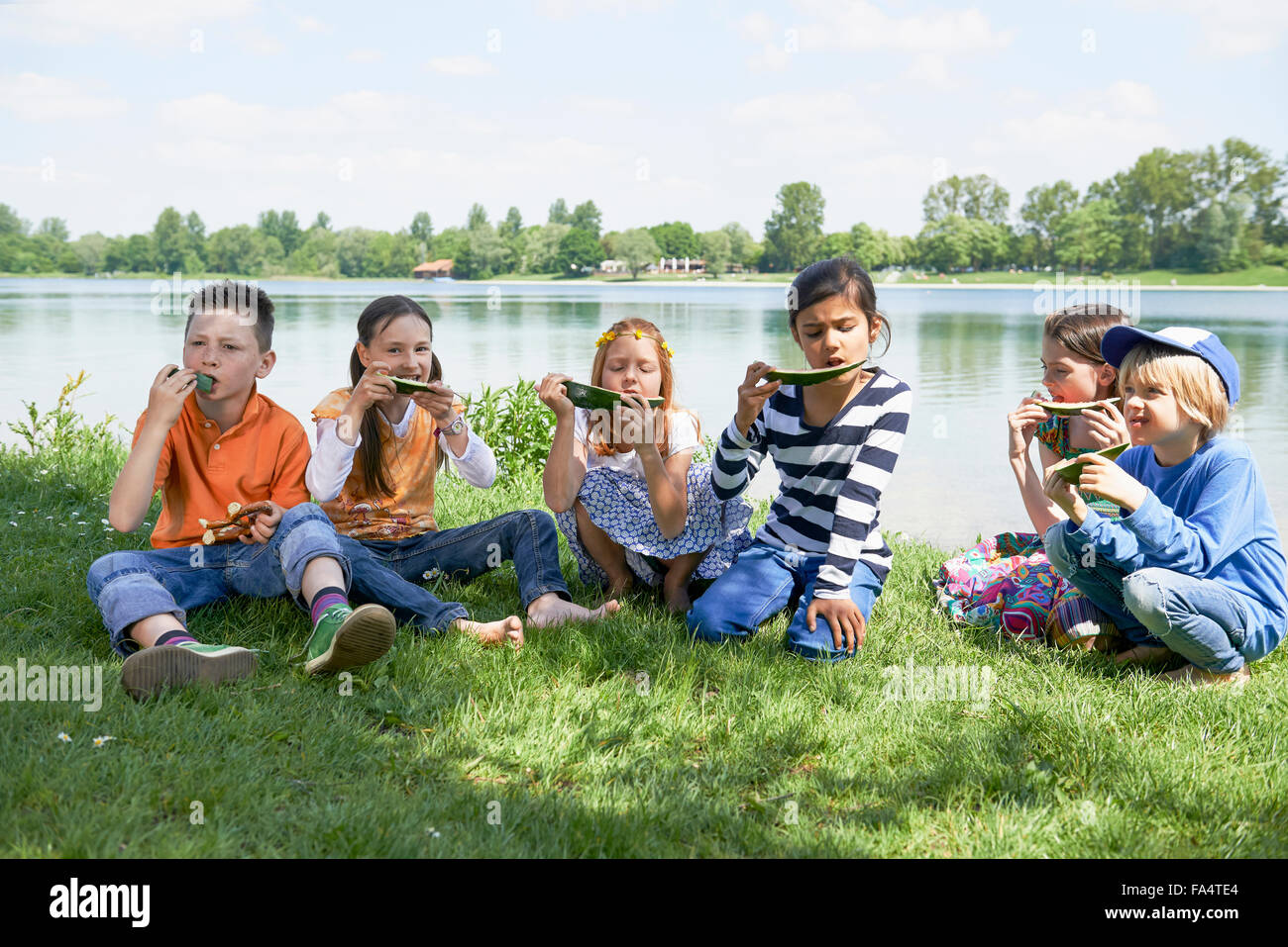 Los niños que disfrutan de rebanadas de sandía en picnic, Munich, Baviera, Alemania Foto de stock