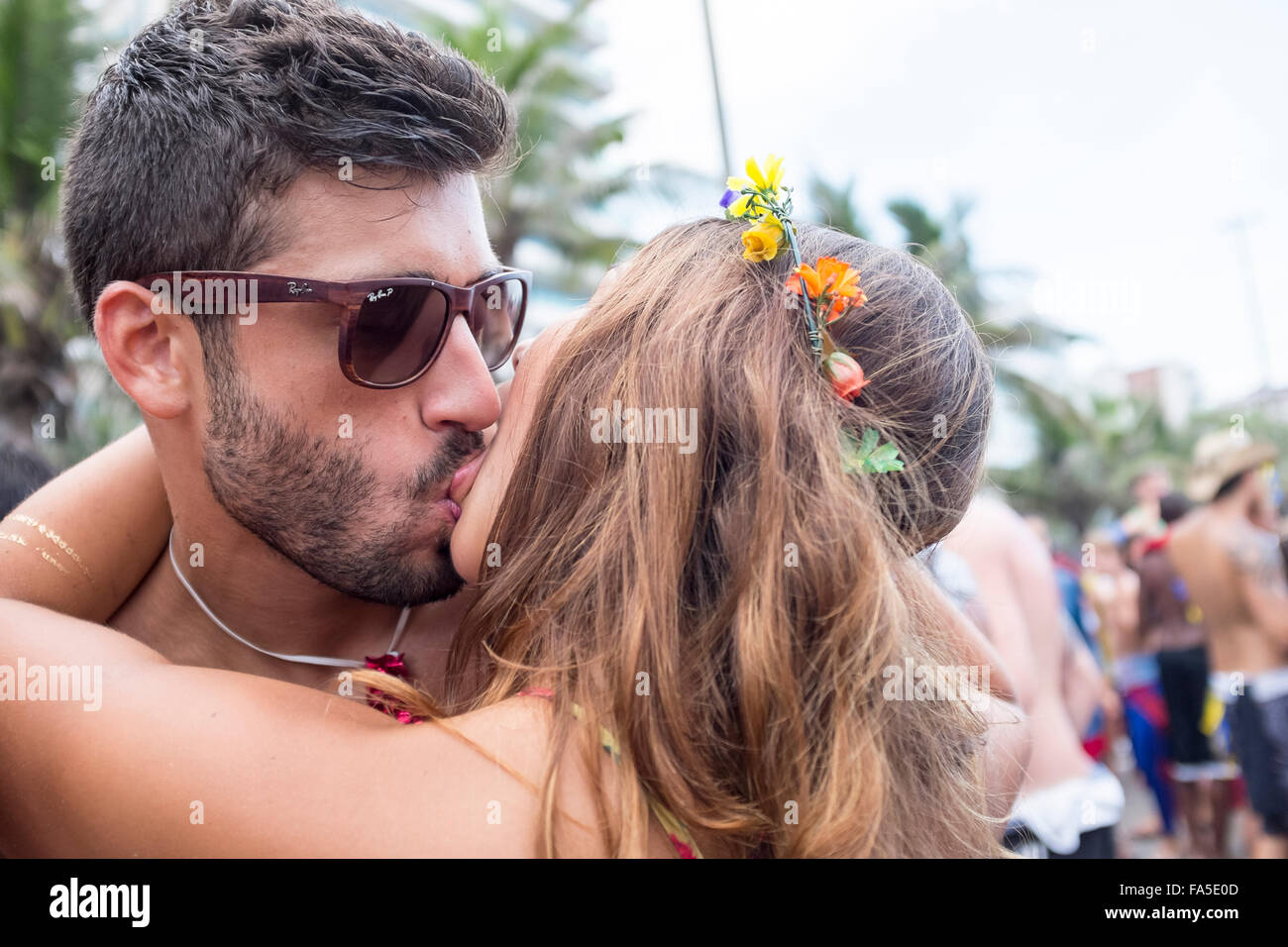 Río de Janeiro, Brasil - 14 de febrero de 2015: el joven matrimonio brasileño besos en medio de una comparsa de carnaval fiesta en la calle. Foto de stock