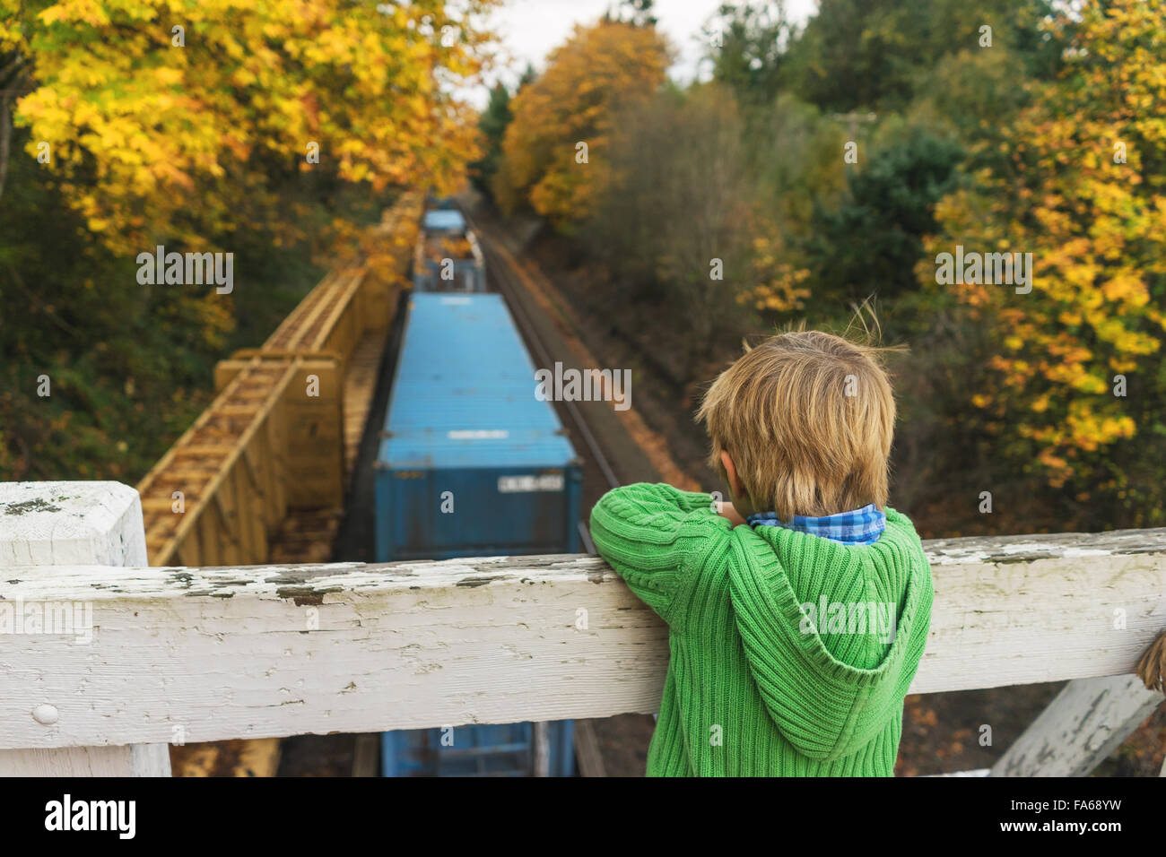 Chico busca en el puente permanente en tren por debajo Foto de stock