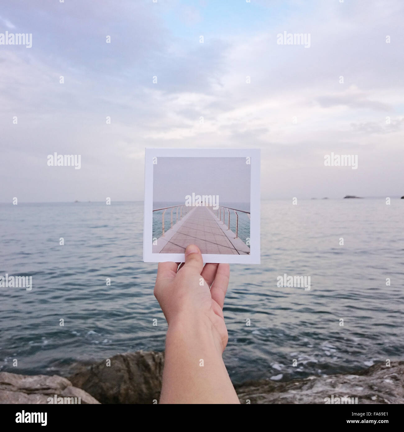 La mano humana la celebración de transferencia de impresión fotográfica  instantánea frente al mar Fotografía de stock - Alamy