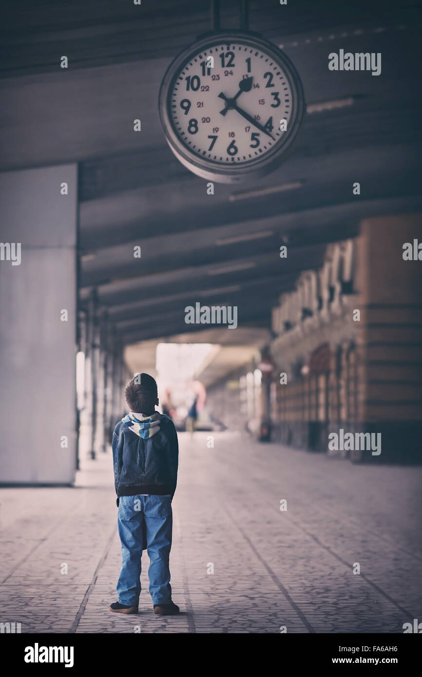 Niño mirando hacia arriba en el reloj Fotografía de stock - Alamy
