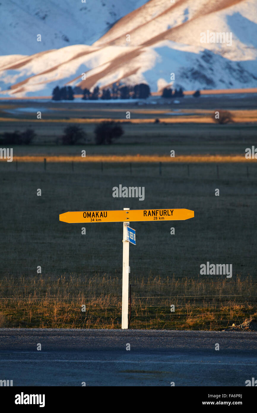 - Omakau Ranfurly, señal de tráfico en la carretera estatal 85, y Ida range en invierno, Colinas Creek, Maniototo, Central Otago, Nueva Zelanda Foto de stock