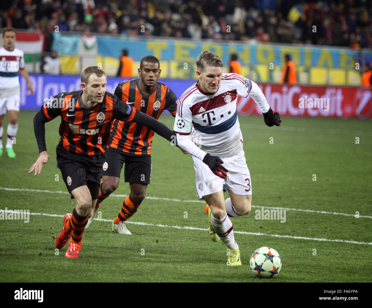 LVIV, Ucrania - Febrero 17, 2015: Bastian Schweinsteiger del Bayern de Múnich (R) pelea por un balón con el Shakhtar Donetsk jugadores d Foto de stock