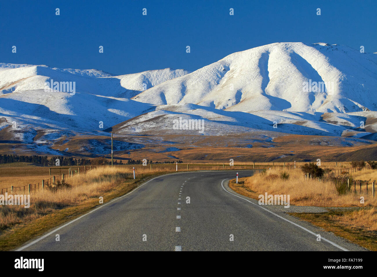 Carretera cerca de Hawkdun Oturehua y rango, Maniototo, Central Otago, Isla del Sur, Nueva Zelanda Foto de stock