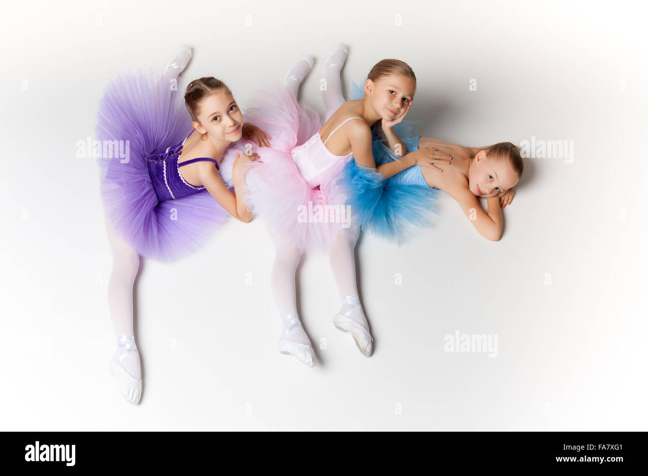 Tres Niñas De Ballet Que Se Sientan En Zapatillas De Punta Juntos