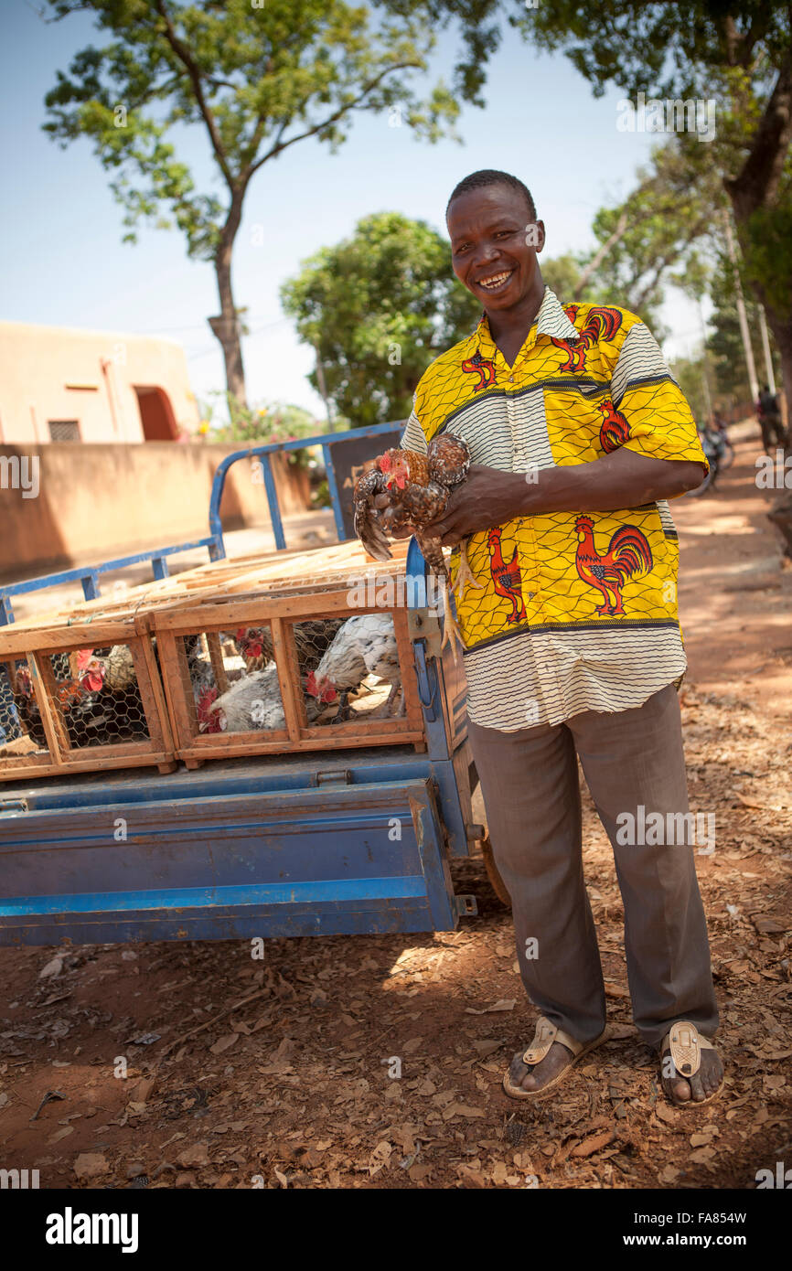 Un vendedor de pollos en su remolque de cargas en el mercado de aves de corral en Banfora, Burkina Faso. Foto de stock