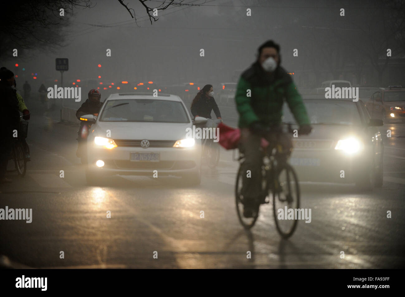 Las personas usan máscaras como una espesa neblina de sobres de contaminación del aire en Beijing, China. 01-Dec-2015 Foto de stock