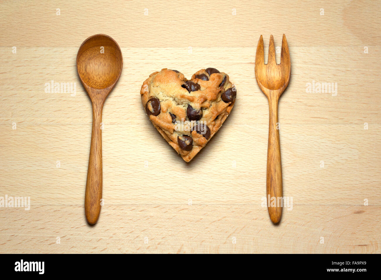 Corazón chocolate chip cookie en tabla de madera Foto de stock