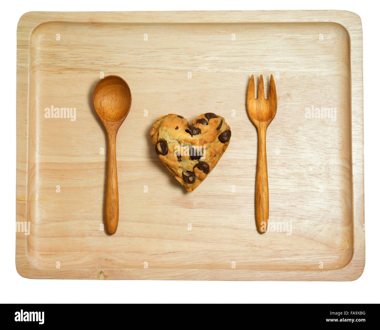 Corazón cookie con chips de chocolate en bandeja de madera aislado sobre fondo blanco. Foto de stock