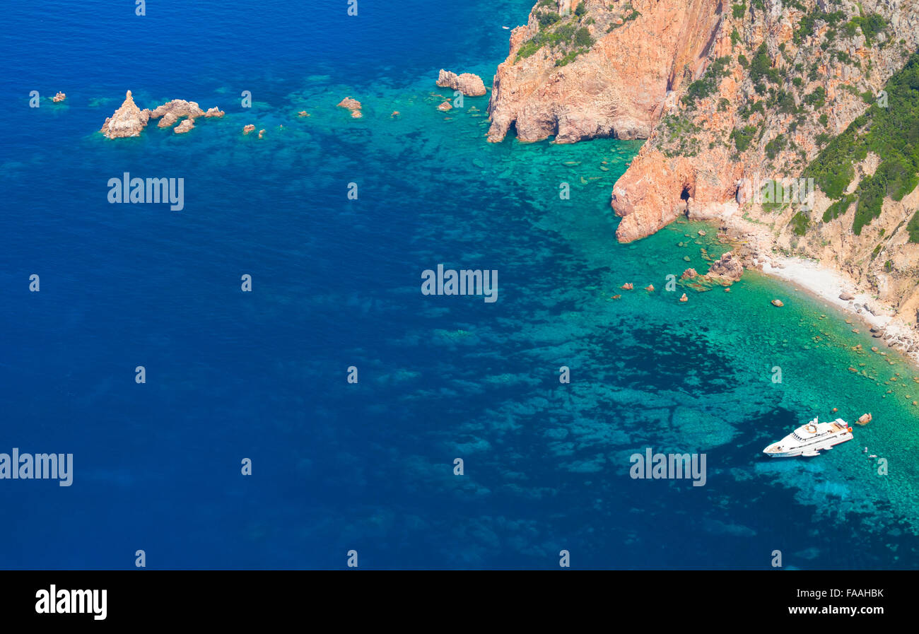 Blanco de lujo placer yate anclado cerca de la costa rocosa de la isla de Córcega, vista panorámica Foto de stock