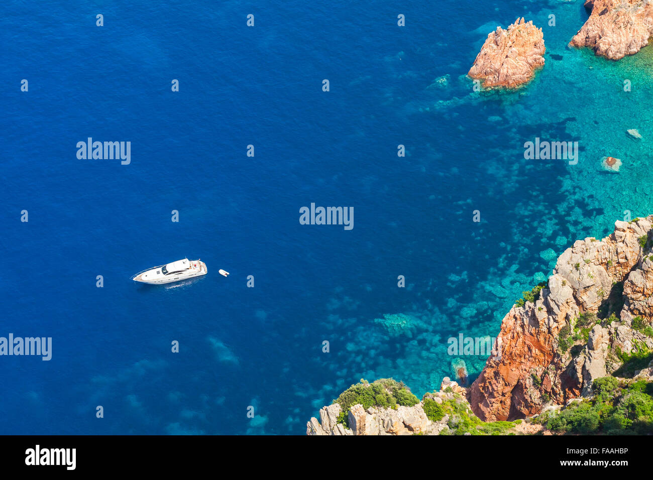 Placer blanco barco anclado cerca de la costa rocosa de la isla de Córcega Foto de stock