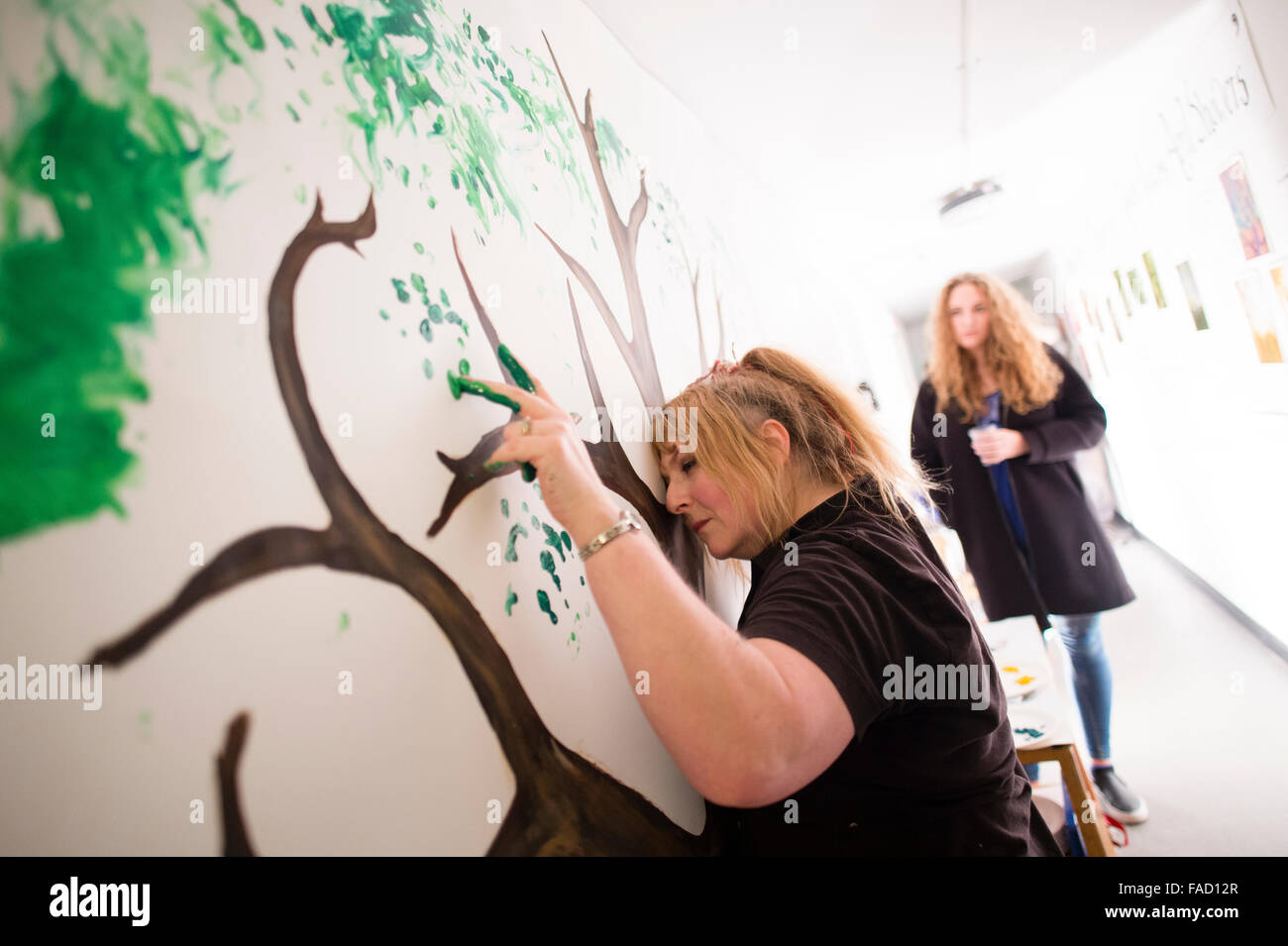 La educación artística en el REINO UNIDO: una mujer mujer estudiante crear una pieza de arte de performance en vivo action painting durante una exposición de obras de estudiantes de artes visuales en una galería en la Escuela de Arte de la Universidad de Aberystwyth, Gales, Reino Unido Foto de stock