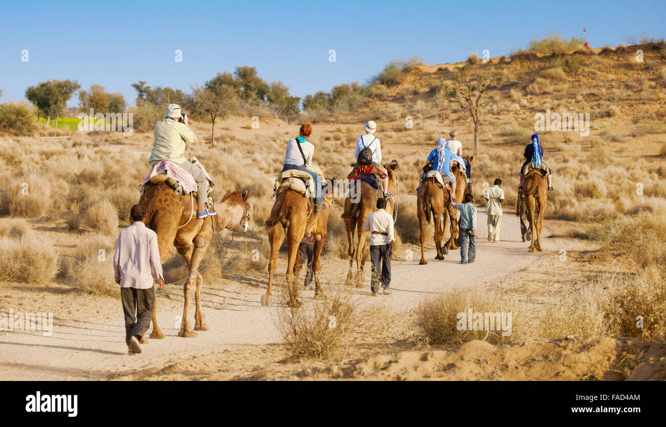 Caravana de camellos safari paseo con los turistas en el desierto de Thar, cerca de Jaisalmer, India Foto de stock