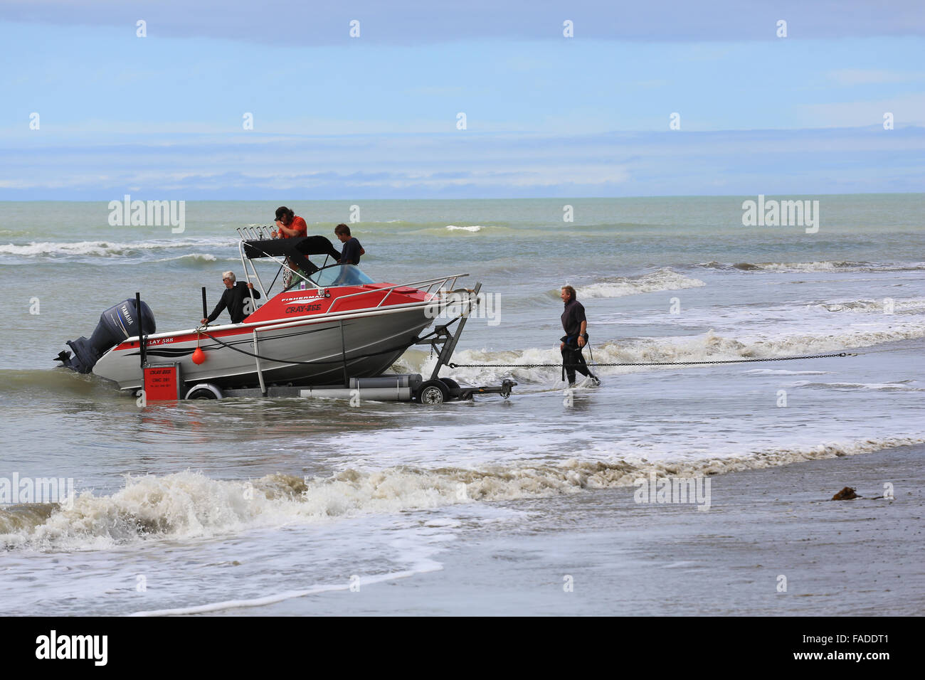 Un pescador McLay barco es acarreada fuera del agua a través de la playa en un barco de remolque a Clifton, Hawke's Bay, Nueva Zelandia. Foto de stock