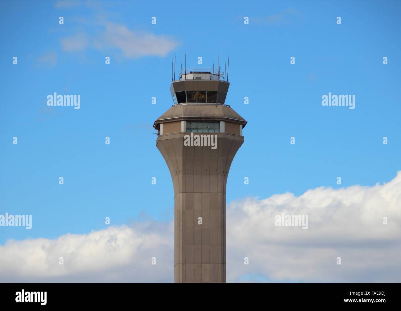 La parte superior de la torre de control del aeropuerto de gris con las nubes y el cielo azul Foto de stock