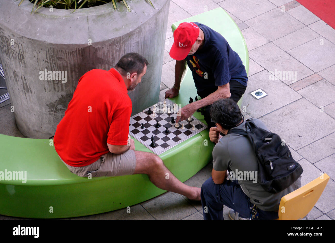 Dos hombres con un juego de ajedrez que se juega al aire libre en un espacio público Foto de stock