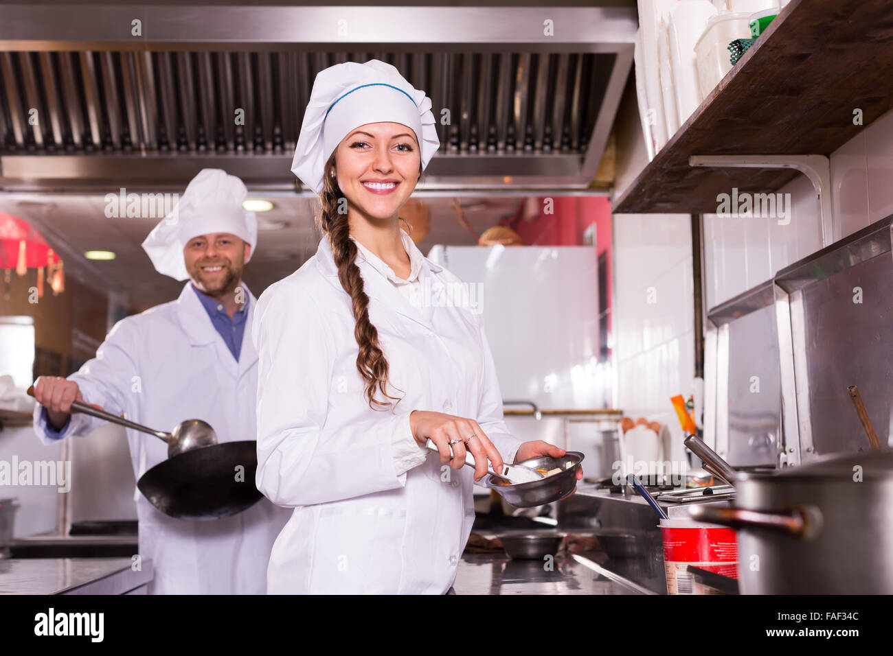 Retrato de feliz chef con hermosa joven ayudante en la cocina en la  cafetería Fotografía de stock - Alamy