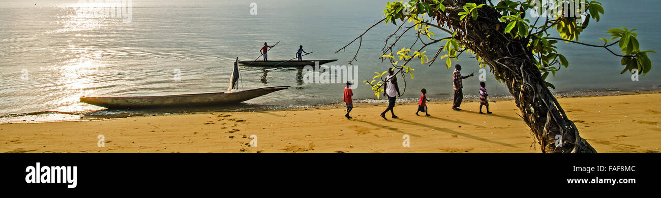 Los aldeanos caminar a lo largo de una playa en la isla de SEI, la tortuga Islas, Sierra Leona. Foto de stock