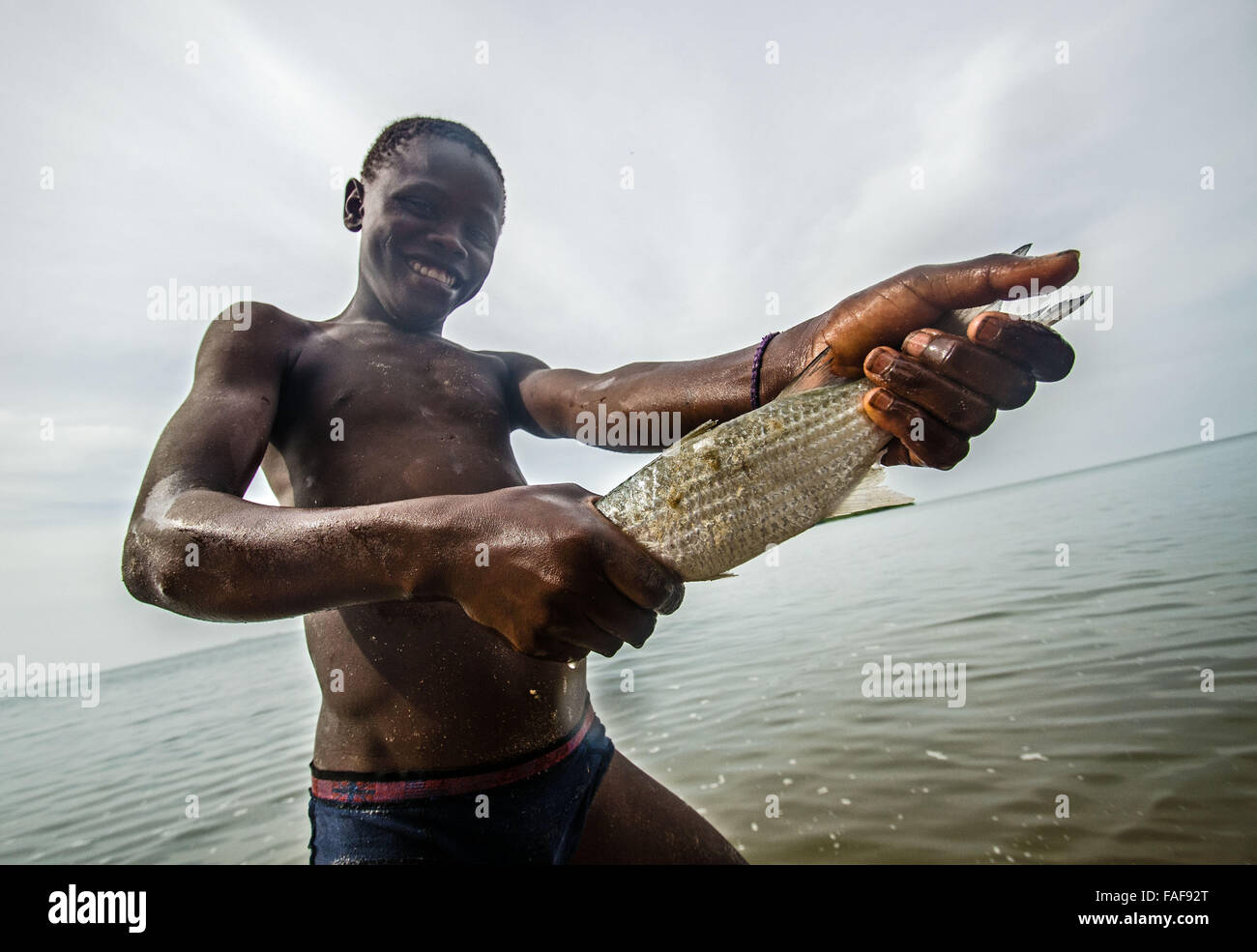 Chico con pescado en las Islas de la tortuga, Sierra Leona. Foto de stock