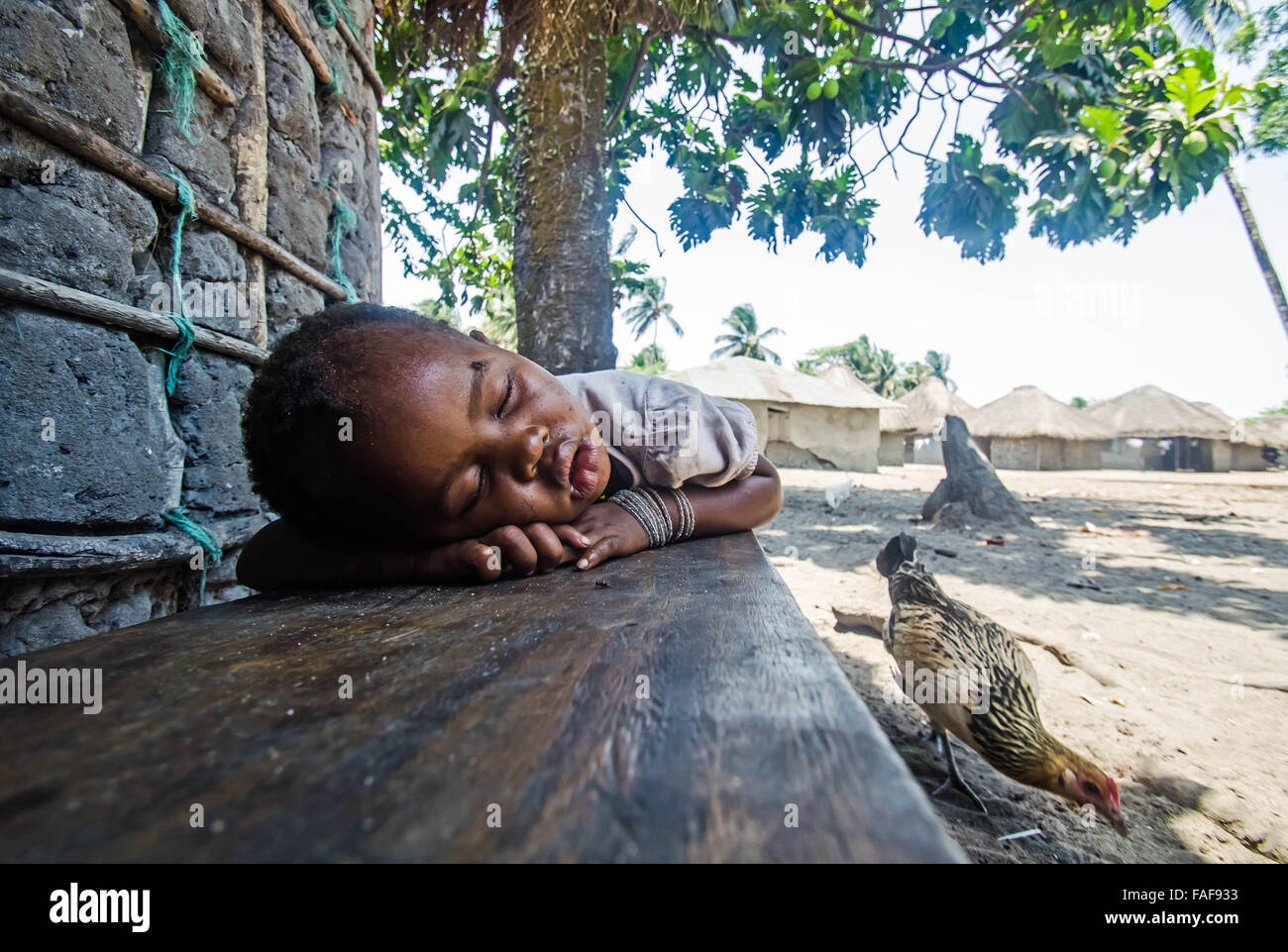 Un niño dormido en un banco sobre Baki isla Tortuga, islas, Sierra Leona. Foto de stock