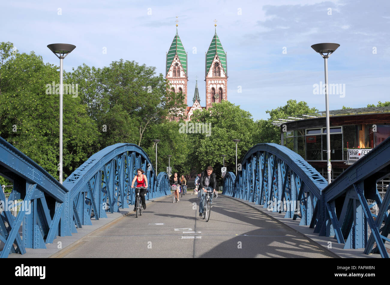 Los ciclistas en la hora punta de la mañana cruzando el puente azul, un ciclo/puente peatonal a lo largo de las líneas de ferrocarril en Friburgo. Foto de stock