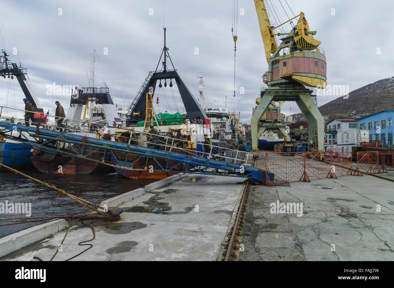 Los arrastreros de pesca de atraque y una antigua grúa en el puerto de Petropavlovsk-Kamchatskiy, Kamchatka, Rusia. Foto de stock