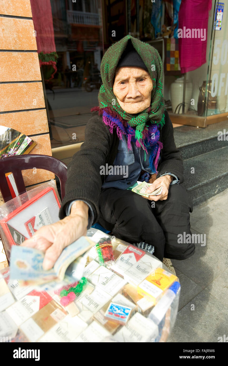 Señora vietnamita vendiendo cigarrillos en el barrio antiguo de Hanoi, Vietnam Foto de stock