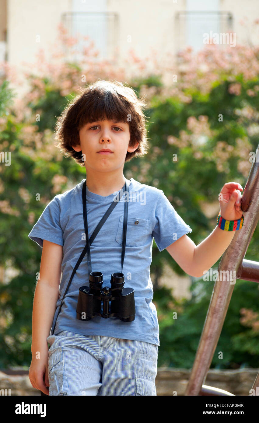 Birdwatcher joven un chico de siete años con prismáticos Foto de stock